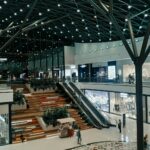 Nowoczesne wnętrze pasażu handlowego z zielenią i przeszklonym sufitem