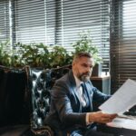 Starszy biznesmen w garniturze analizuje dokumenty w nowoczesnym biurze