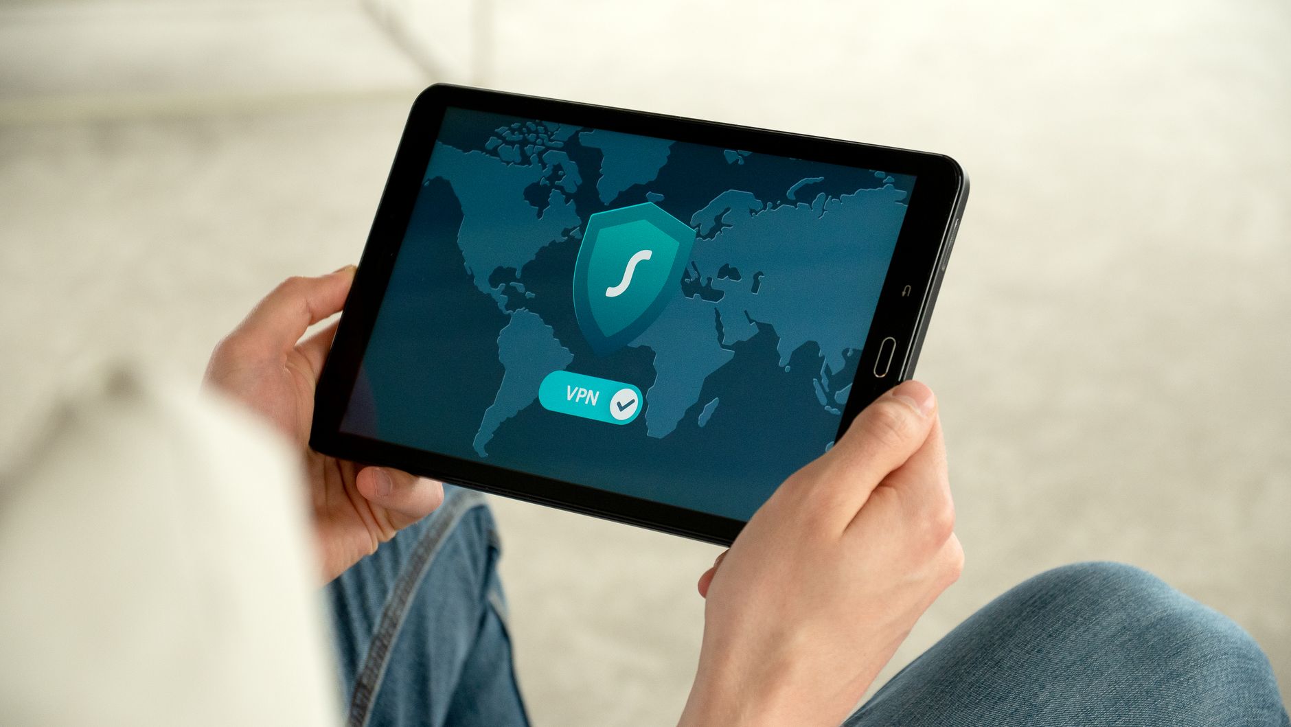Osoba trzyma tablet z ekranem połączenia VPN zabezpieczającego internet