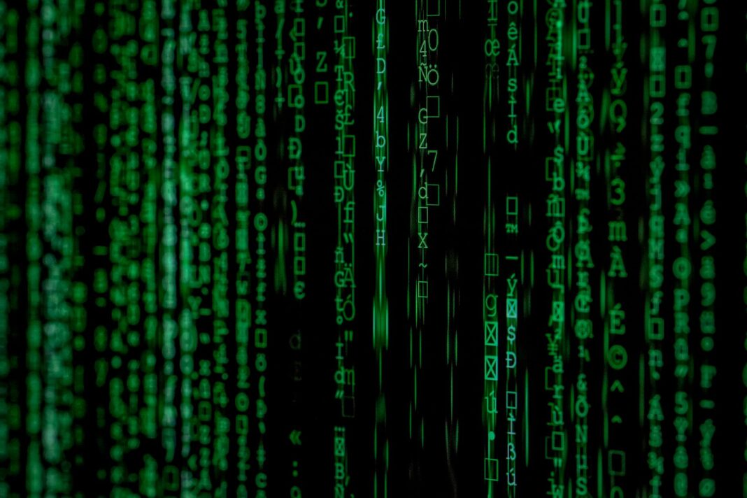 Zielone cyfry binarne na abstrakcyjnym tle przypominającym szyfr matrix